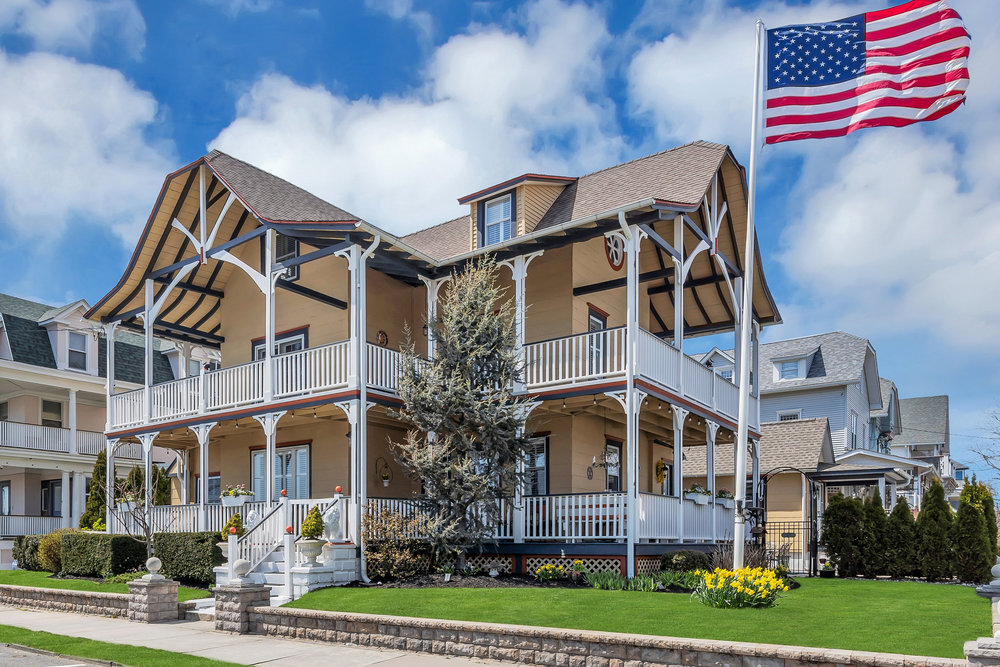 Victorian style home with American flag waving.