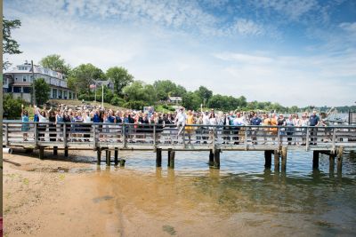 Large group of people standing on a pier and waving at the camera.